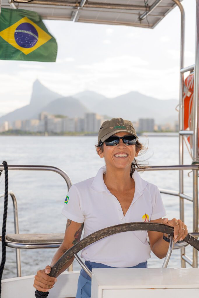Funcionária da DDrio, cliente da Fizzing, controlando um barco no timão. 